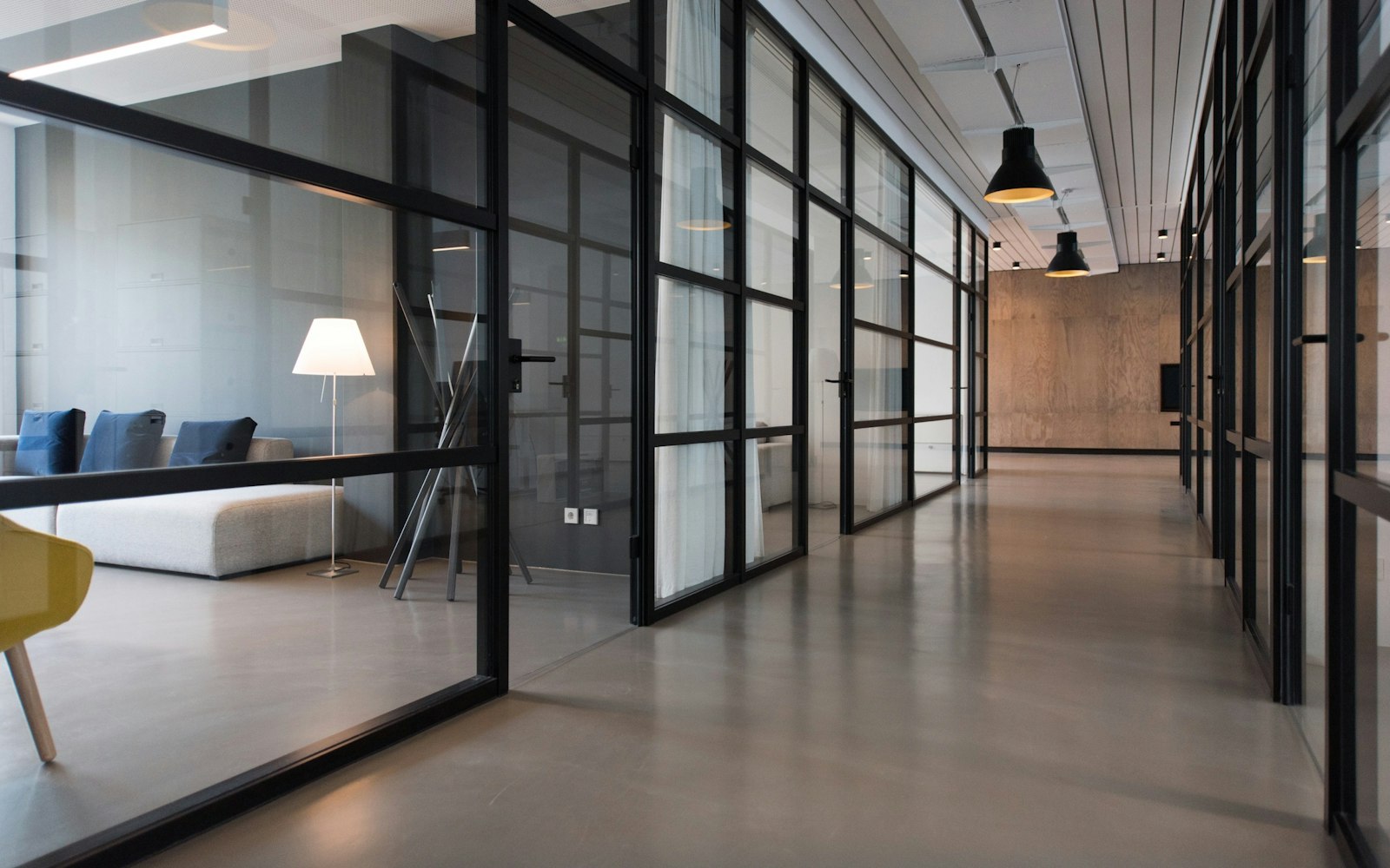A quiet glass-walled office corridor
